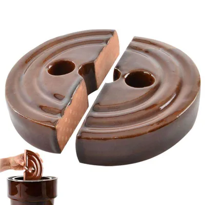 Two halves of a brown ceramic sauerkraut weight are shown, with a hand placing another weight into a crock.