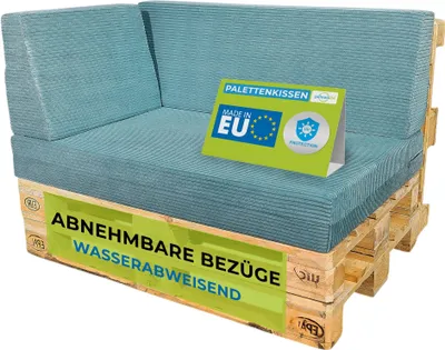 A corner sofa cushion set made from corduroy fabric, placed on wooden pallets. A sign indicating 'Made in EU' and 'Palettenkissen' is placed on the cushions.