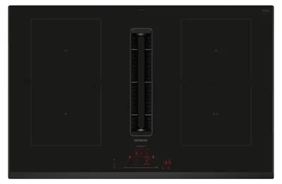 A top-down view of a black induction cooktop with an integrated downdraft ventilation system.