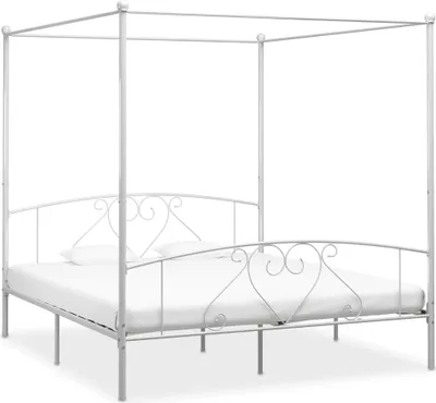 A white canopy bed frame with a mattress.