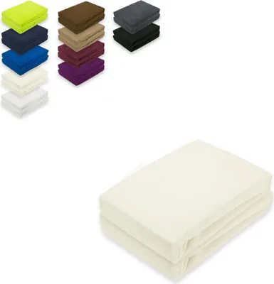 A stack of folded cream-colored fitted sheets is shown on a white background. To the left, there are stacks of fitted sheets in various colors.