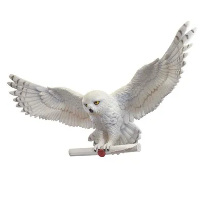 A decorative snowy owl figurine with outstretched wings holding a scroll.