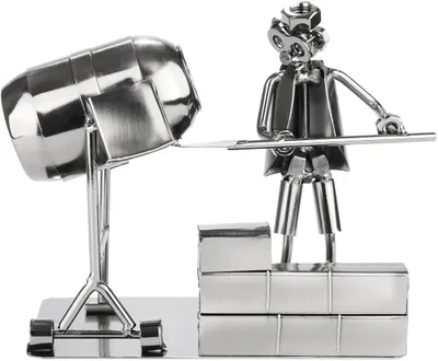 A metal figurine of a construction worker with a cement mixer.