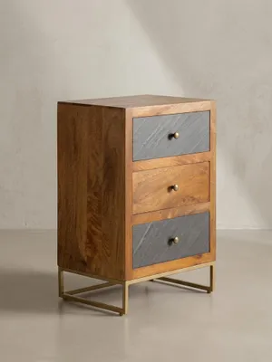 Der dreischübige Nachttisch aus braunem Mangoholz zeigt aus der 3/4-Perspektive seine schlanke Form und die Materialkombination aus Holz, Steinoptik und Metall._#sku_SAFWL6.767#