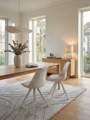 Zwei weiße skandinavische Esszimmerstühle an einem Eichentisch in einem hellen, minimalistischen Esszimmer, das für ein gemütliches Beisammensein gestaltet ist._#sku_SAFWL6.136#