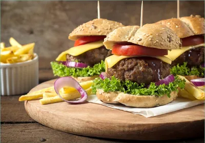 Produktbild von Wallario Fototapete Vliestapete, seidenmatte Oberfläche, einfache Verarbeitung, Größe 200 x 140 cm, Motiv Saftige Burger auf Holzbrett