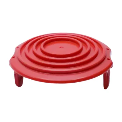 A red plastic cover with concentric circles and three legs, isolated on a white background.