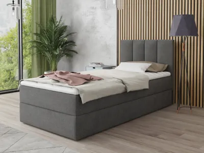 A bedroom scene with a bed, plant, and lamp.