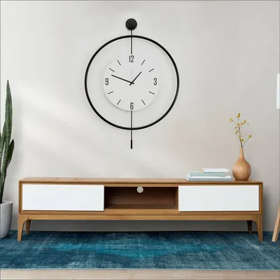 A modern living room setup with a wall clock and a TV stand.