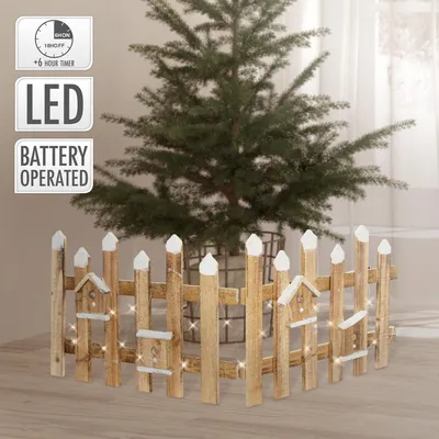 A small artificial Christmas tree surrounded by a decorative wooden fence with LED lights.