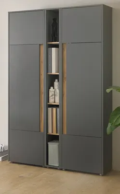 A tall, narrow gray cabinet with wooden accents, featuring open shelves with books and bottles.