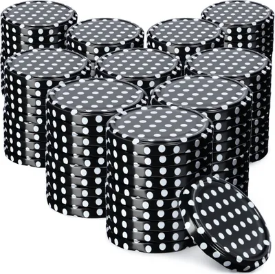 Stacks of black jar lids with white polka dots are arranged in rows on a white background.