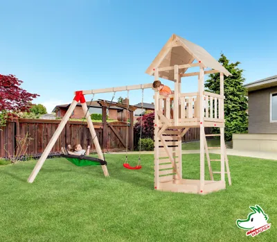 Productafbeelding van Tabaluga drakenhuis met zadeldak, naturel, set inclusief een aanbouwschommel met een nestschommel, een enkele schommel en een zandbak. De bekleding van de schommel is groen-zwart