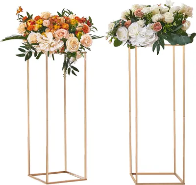 Two golden geometric flower stands with floral arrangements on top, displayed against a white background.