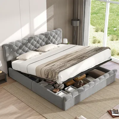 A grey upholstered bed with drawers underneath is displayed in a room with natural light coming from a window.