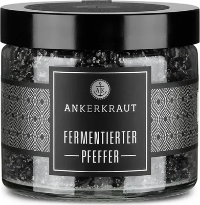 A glass jar of fermented pepper with a label.