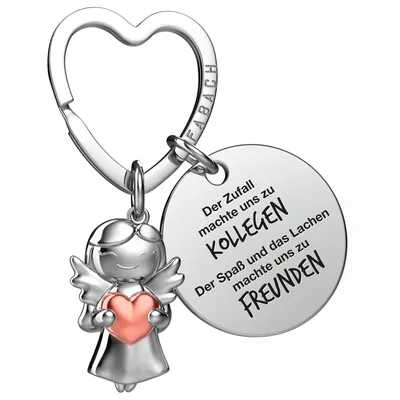 A silver angel keychain with a pink heart, attached to a heart-shaped keyring. A circular charm with German text is also attached.