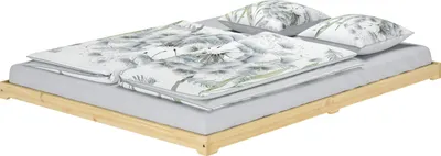 A low-profile wooden bed frame with a mattress, duvet, and pillows, all featuring a dandelion-like floral pattern.