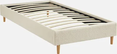A bed frame with a slatted base, upholstered in white bouclé fabric, shown from a diagonal angle against a white background.