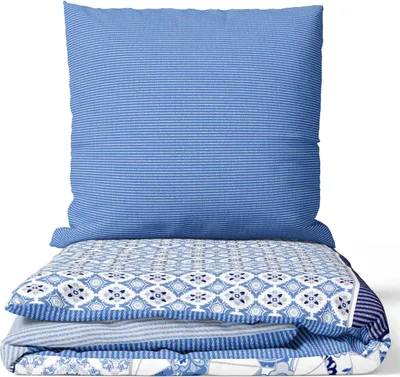 A neatly folded set of bedding, including a pillow and duvet cover, with a blue and white striped pattern and a decorative paisley pattern.