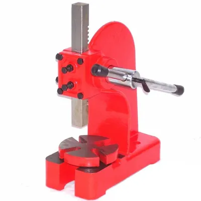 A red and gray manual lever press on a white background.