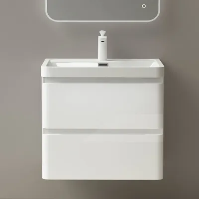A white bathroom vanity with a sink and faucet against a gray wall.