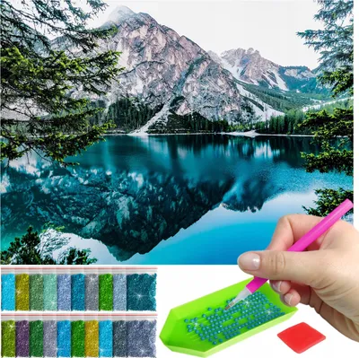 A diamond painting kit with a landscape image and accessories.