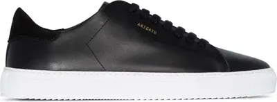 A black leather sneaker with a white sole is shown from the side.