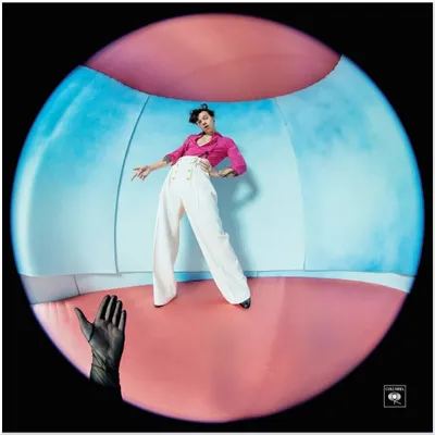 A person posing in a colorful, curved room.