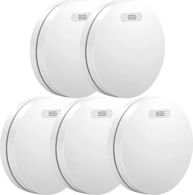 A group of five white smoke detectors are arranged in a staggered formation against a white background.