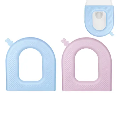 Two toilet seat covers, one blue and one pink, are shown against a white background. A partial view of a toilet seat is visible in the upper right corner.