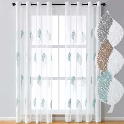 Sheer curtains with a leaf pattern hanging on a window.