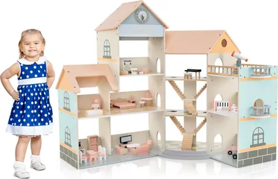 A young child stands next to a large, multi-story wooden dollhouse filled with miniature furniture.