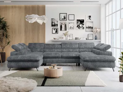 A modern living room with a large sectional sofa, coffee table, and wall art.