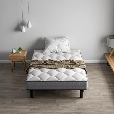 A bedroom scene with a single bed, nightstand, and lamp.
