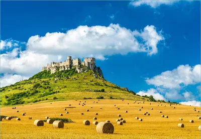 Produktbild von Wallario Fototapete Vliestapete, seidenmatte Oberfläche, einfache Verarbeitung, Größe 300 x 210 cm, Motiv Alte Burg über Feldern