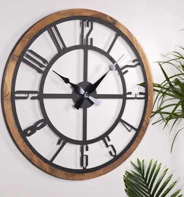 A close-up shot of a large, round wall clock with a wooden frame and black metal Roman numerals and hands.