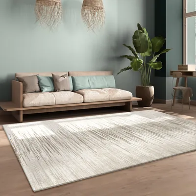 A living room scene with a sofa, rug, plant, and desk.