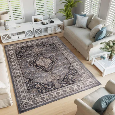 A living room scene with a rug, sofa, and coffee tables.