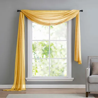 A yellow sheer scarf draped over a window.