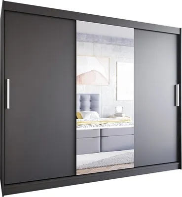 A modern sliding door wardrobe with a mirror in the center, placed in a bedroom setting. The wardrobe is dark gray and reflects a bed with pillows and artwork on the wall.