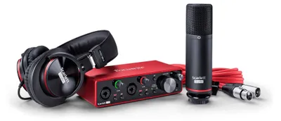 A studio recording setup including headphones, an audio interface, and a microphone.