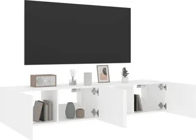 A white TV stand with open cabinets and a large black TV mounted above it.