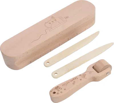 A set of wooden sewing tools including a seam roller, two creasing tools, and a storage box, arranged on a white background.