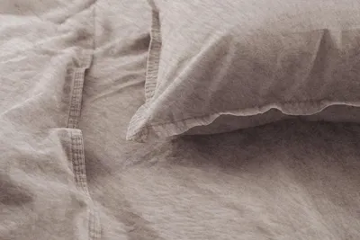 A close-up view of textured fabric, likely bedding, with visible stitching.