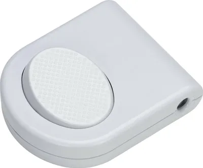 A white foot switch with a textured circular button.