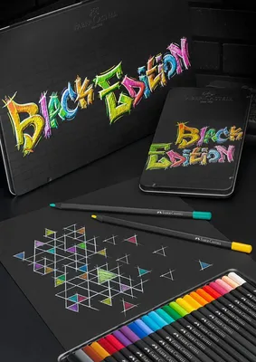 A set of colored pencils and a tin are displayed on a black surface, with a drawing on black paper in the foreground.
