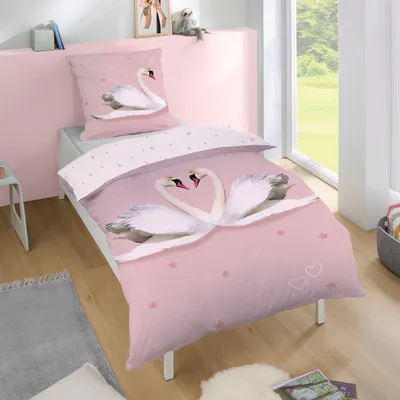 A child's bed with pink bedding featuring swans, set in a bedroom with a window.