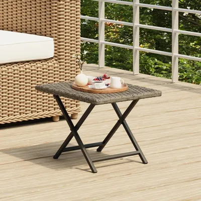 A small square table with a tray of fruit and drinks on a wooden deck.