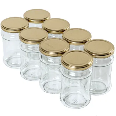 A group of empty glass jars with gold lids are arranged in a diagonal formation against a white background.